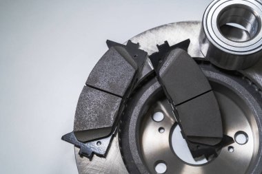 Beyaz bir masada fren yastıkları ve otomobil parçaları.