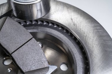 Beyaz bir masada fren yastıkları ve otomobil parçaları.