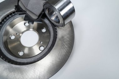 Beyaz bir masada fren yastıkları ve otomobil parçaları.