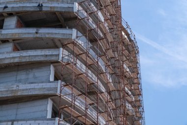 Yüksek bir binanın duvarında iskele var.