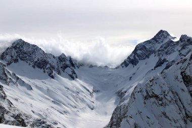 Karlı Dağlar bulutların tepesinde mavi gökyüzü Kafkaslar