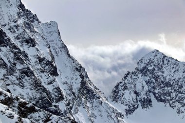 Karlı Dağlar bulutların tepesinde mavi gökyüzü Kafkaslar