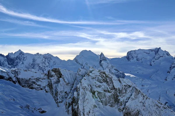 Montañas nevadas picos en las nubes cielo azul Cáucaso —  Fotos de Stock