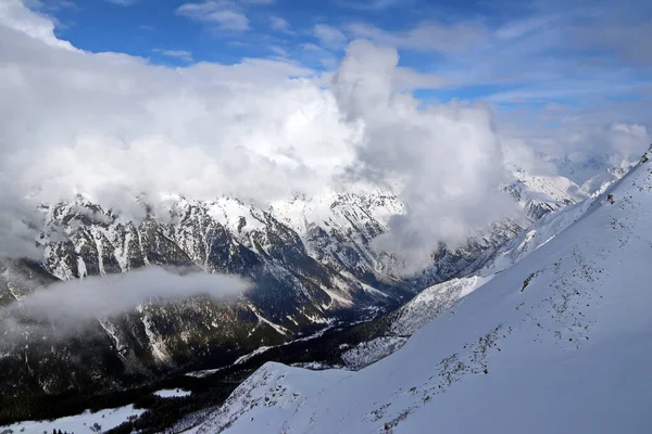 Karlı Dağlar bulutların tepesinde mavi gökyüzü Kafkaslar