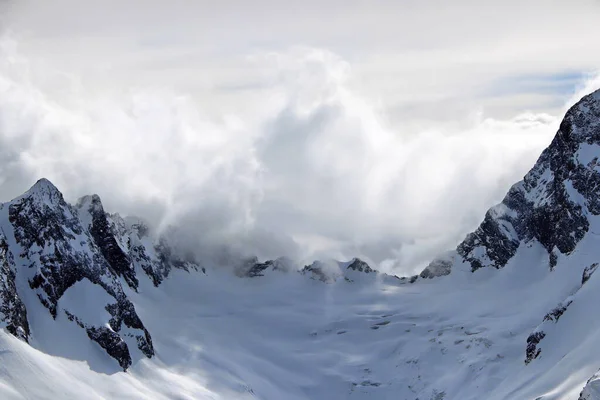 Karlı Dağlar bulutların tepesinde mavi gökyüzü Kafkaslar