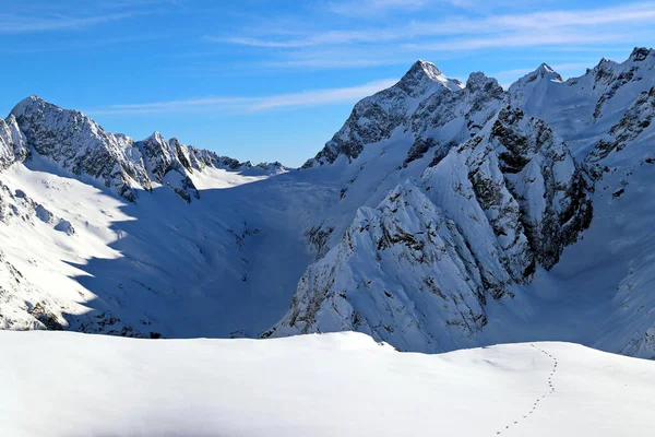 Montañas nevadas picos en las nubes cielo azul Cáucaso —  Fotos de Stock