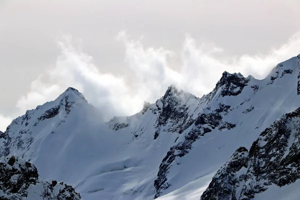 Montañas nevadas picos en las nubes cielo azul Cáucaso — Foto de Stock