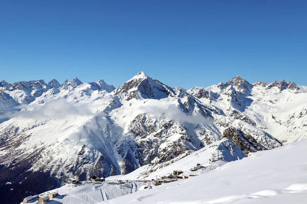Snöiga berg toppar i molnen blå himmel Kaukasus — Stockfoto