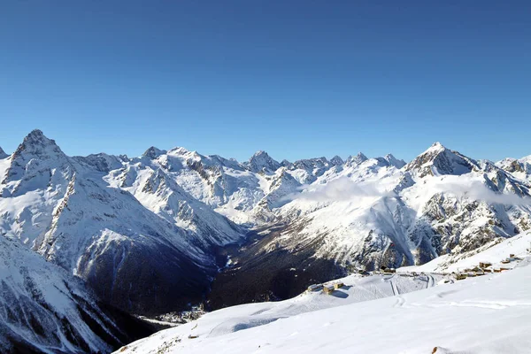 Sněžné hory vrcholí v mracích modrá obloha Kavkaz — Stock fotografie