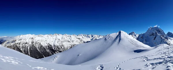 Vista panorámica de las montañas nevadas picos en las nubes cielo azul Cáucaso — Foto de Stock