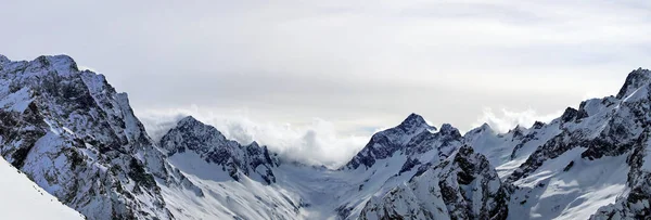 Panoramic view of snowy mountains peaks in the clouds blue sky Caucasus — Stock Photo, Image