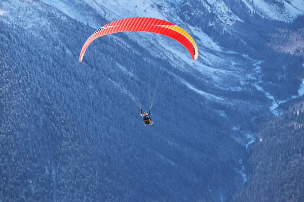 Paraplane πετούν πάνω από χιονισμένα βουνά του Καυκάσου ηλιόλουστο μπλε ουρανό — Φωτογραφία Αρχείου