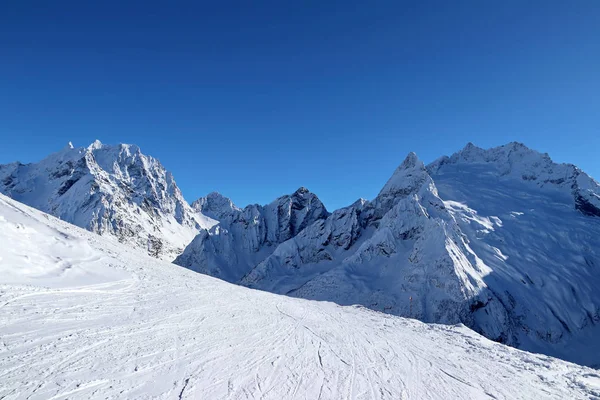 Picos nevados de las montañas y el cielo azul del Cáucaso —  Fotos de Stock