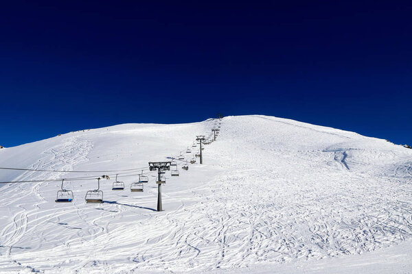 skilift in the snowy mountains and deep blue sky