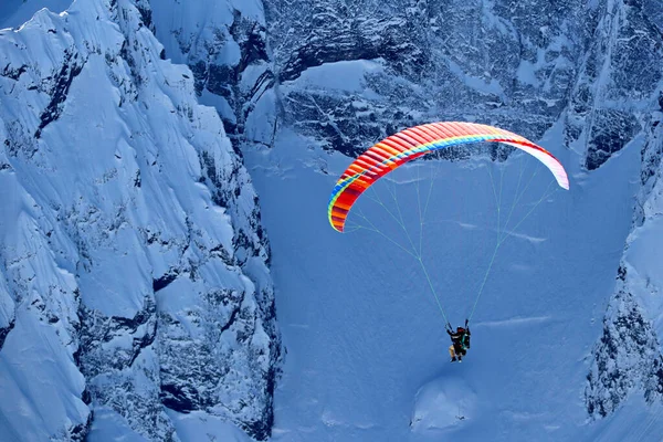 Karlı Kafkaslar üzerinde uçan paraşüt uçağı güneşli mavi gökyüzü