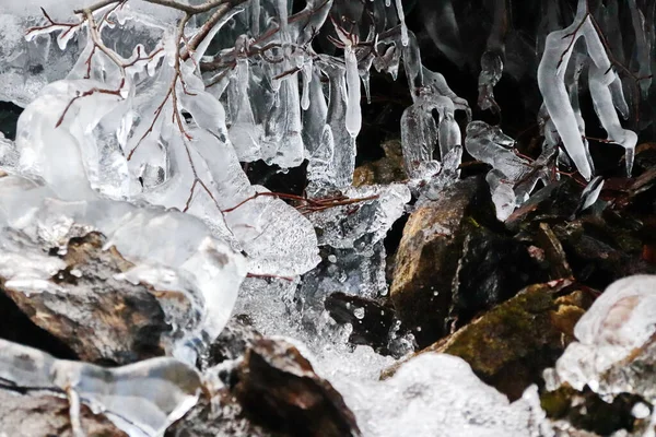 Horský potok teče horskými kameny, sněhem a ledem — Stock fotografie