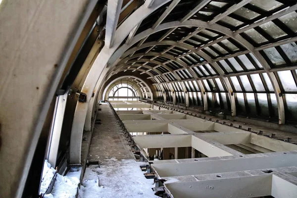 Terk edilmiş bir otelin ana salonunun cam kubbesinin altında.