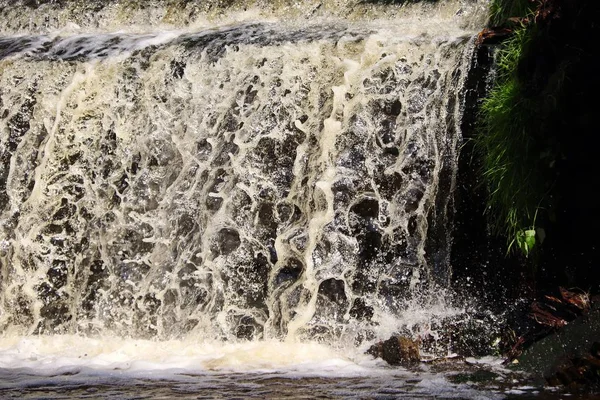 water stream cascade falling on the rocks close up