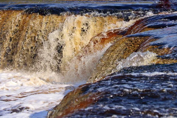 water stream cascade falling on the rocks close up