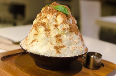 Buz açık dönüyor siyah Asya tatlılar bir kase toz kakao ile tepesinde süt alın.