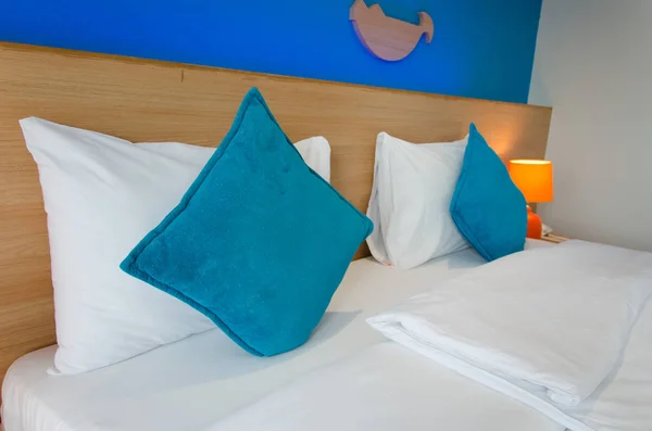Blaues Kissen auf dem Bett — Stockfoto