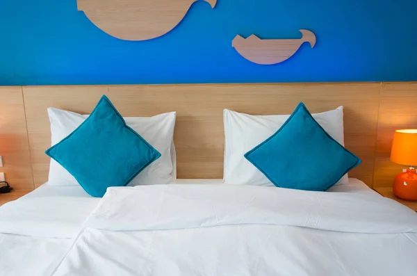 Blaues Kissen auf dem Bett — Stockfoto