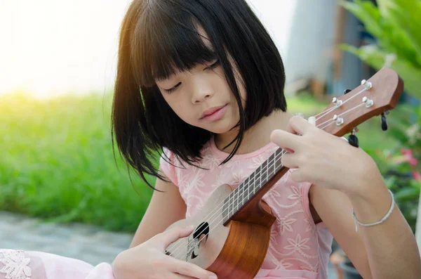 Menina asiática tocando o ukulele — Fotografia de Stock