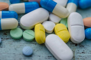 Tabletler ve kapsüller ahşap zemin üzerinde.