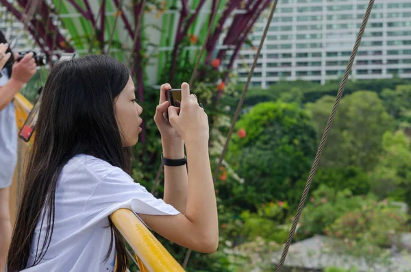 Young girls use mobile phones to take pictures — Stock Photo, Image