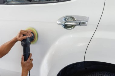 Cilalayan, arabaları kaplayan bir adam. Arabanın cilalanması arabanın yüzeyindeki kirleticilerin temizlenmesine yardımcı olacaktır. Arabanın yüzeyini cilalamak arabayı beyaza boyattıktan sonra parlatacaktır.