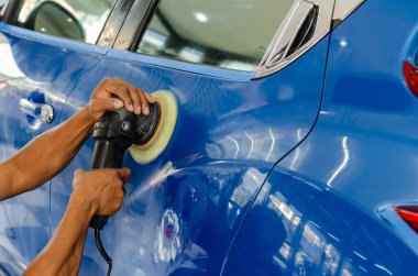 İş aletini tutan adam, arabayı cilalar ve parlatır. Araba temizleme.