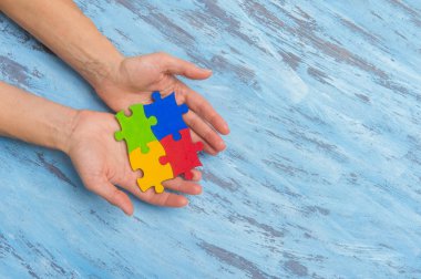 Halkın otizm spektrum bozukluğuna yönelik farkındalığının bir sembolünü çalan eller.