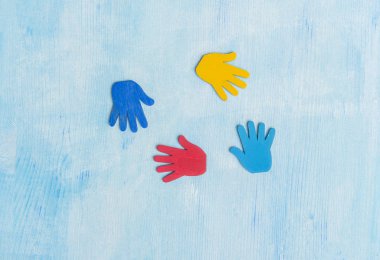 Mavi arka planda renkli yapboz elleri. Dünya Otizm Farkındalık Günü Kavramı