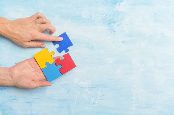hands playing a puzzle symbol of Public awareness for autism spectrum disorder.