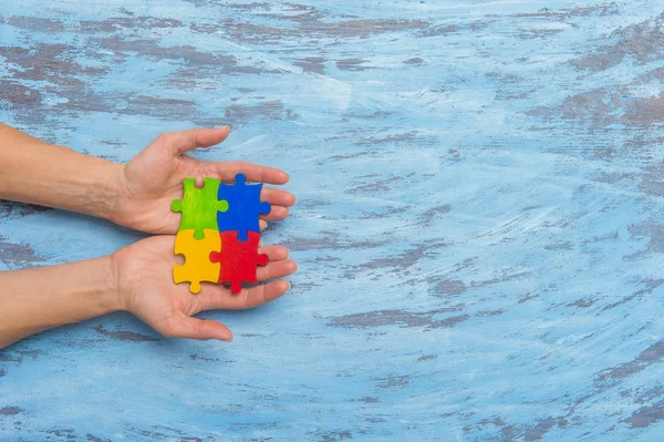 hands playing a puzzle symbol of Public awareness for autism spectrum disorder.