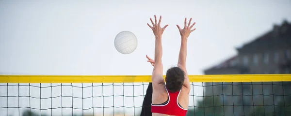 Plaj voleybolunda duvar bloğu yapmak için atlayan atletik bir kadın. — Stok fotoğraf