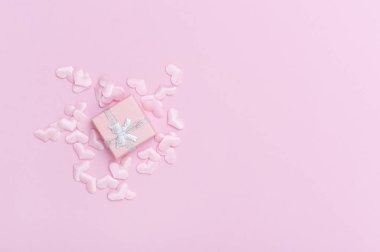 Pembe arka planda kalpleri olan bir hediye kutusu. Sevgililer Günü.