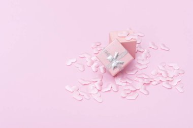 Pembe arka planda kalpleri olan bir hediye kutusu. Sevgililer Günü.