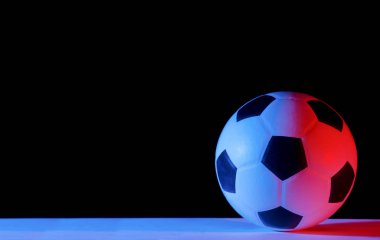 Futbol topu siyah arka planda izole edilmiş. Mavi neon sanatı konsepti
