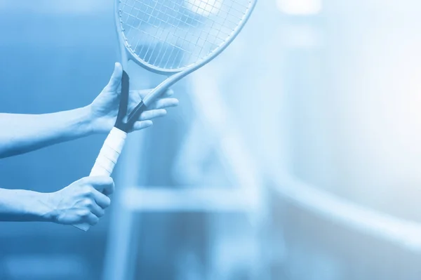 女性のクローズアップはハードテニスコートでテニスラケットを保持しています ブルーフィルター — ストック写真
