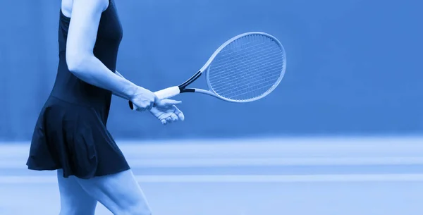 女子近身手握网球拍在硬网球场上 蓝色过滤器 — 图库照片