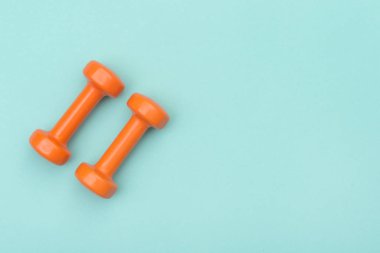 Yeşil arkaplanda turuncu halterler izole edildi