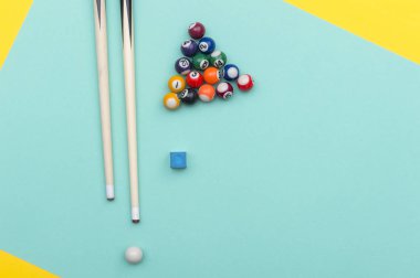 Yeşil ve sarı arkaplanda bilardo ekipmanları.