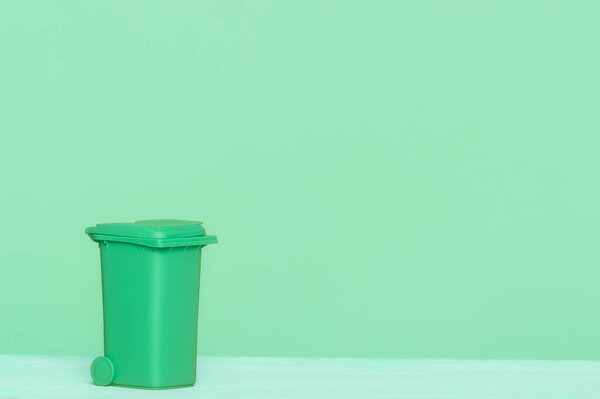 Зеленый пластиковый мусорный бак на зеленом фоне, отлично подходит для переработки концепции и конструкции
.