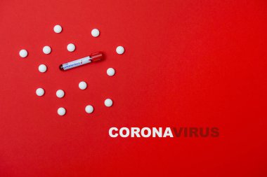 Virus Coronavirus blood test, pills on red copy space background for a banner