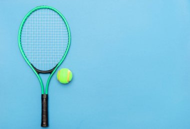 Mavi arka planda tenis topu ve raket. Spor malzemeleri. Düz yatıyordu.