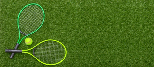 Κάτοψη Του Τένις Ρακέτες Και Μπάλα Από Πράσινο Γρασίδι Οριζόντια — Φωτογραφία Αρχείου