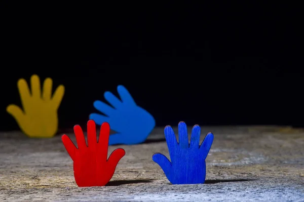 Colorfull puzzles hands on black background. World Autism Awareness Day Concept