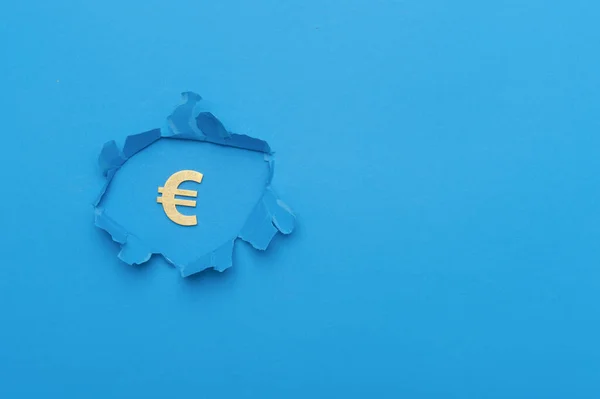 Euro sign in paper cut hole. Drop in revenue. Low salary. Financial and economic.