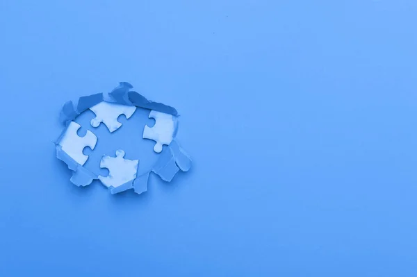 World Autism Awareness, concept with puzzle or jigsaw pattern in paper cut hole. Blue filter